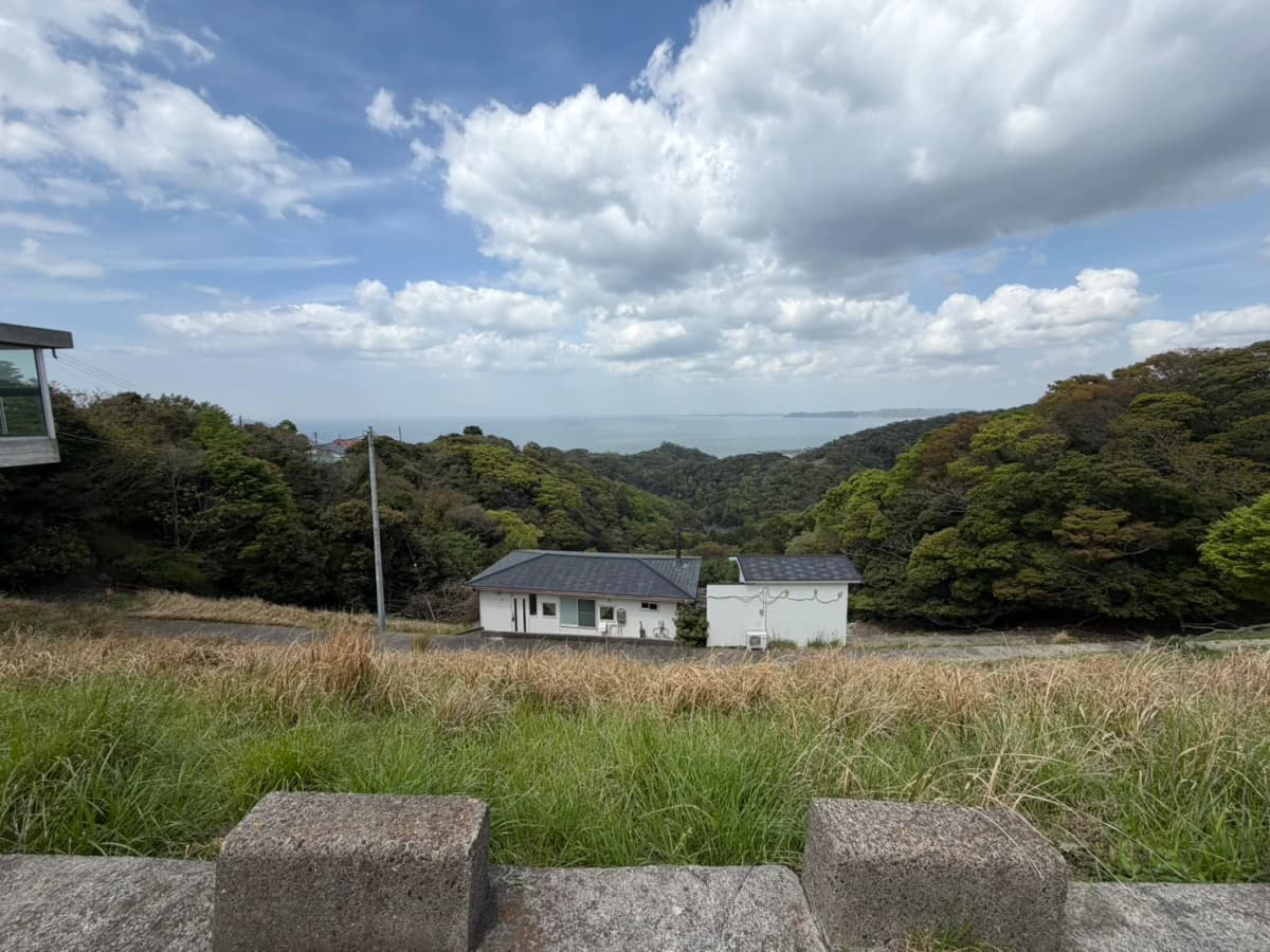 富津市萩生の現地から見える森と海、手前の傾斜地